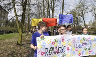 Uczniowie i uczennice z banerami głoszącymi hasła "Równość", "Tolerancja".