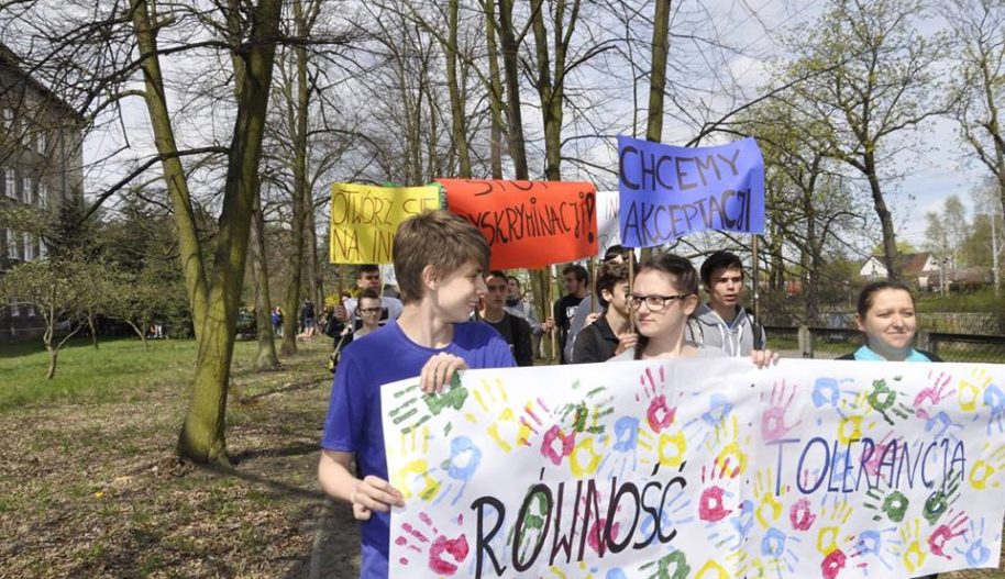 Uczniowie i uczennice z banerami głoszącymi hasła "Równość", "Tolerancja".