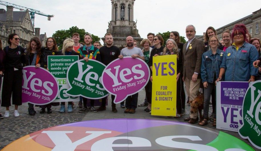 Amnesty International Irlandia w Dublinie, akcja na zewnątrz, grupa aktywistów_aktywistek stoi z banerami za powiedzeniem tak w referendum, które mzadecydowało o usunięciu z konstytucji kraju określenia ochrony życia od począcia.