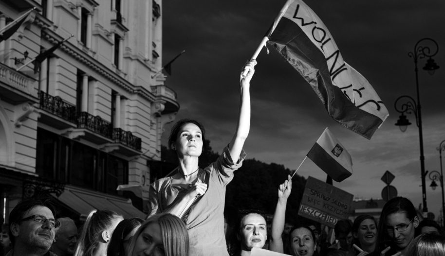 Zdjęcie Adam Lach. Kobieta trzyma polską flagę z napisem Wolność.
