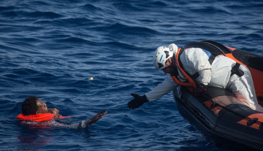 Członek załogi ratowniczej MOAS (Migrant Offshore Aid Station) próbuje ratować mężczyznę, maj 2018.