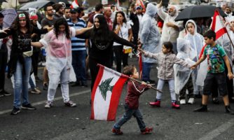 Chłopiec niesie flagę Libanu podczas protestu. Bejrut, 24 październik, 2019.