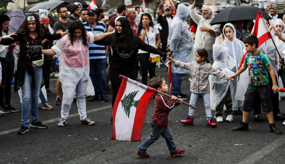 Chłopiec niesie flagę Libanu podczas protestu. Bejrut, 24 październik, 2019.