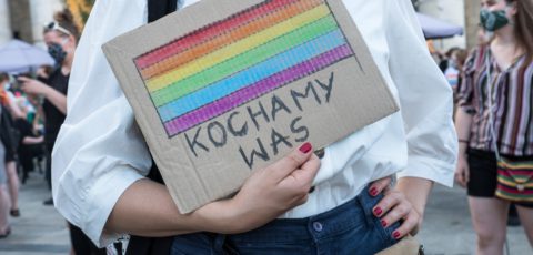 Protest solidarnościowy z osobami LGBTI+ oraz aktywistami_kami, których spotkały represje 7 sierpnia 2020, podczas tzw. tęczowej nocy. Osoba na zdjęciu trzyma karton z namalowanymi tęczowymi barwami i z napisem "kochamy was".