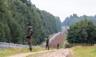 Granica Polski i Białorusi, polsct żołnierze stoją przed postawionym przez nich ogrodzeniem z drutu kolczastego. Krynki, 27 września 2021. Zdjęcie: Dominika Zarzycka