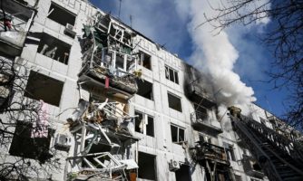 Photo by ARIS MESFirefighters work on a fire on a building after bombings on the eastern Ukraine town of Chuguiv on February 24, 2022, as Russian armed forces are trying to invade Ukraine. SINIS/AFP via Getty Images