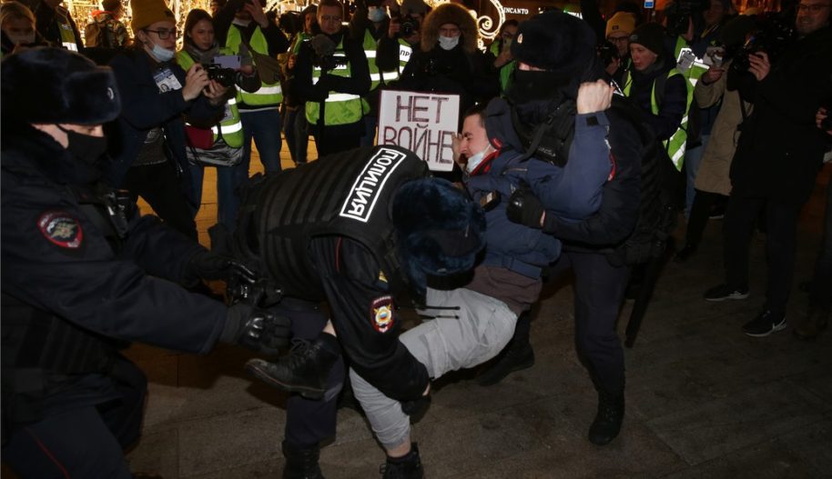 Police officers detain a man holding a placard reading "No war" during a protest at Pushkinskaya Square on February 24, 2022 in Moscow, Russia. (Photo by Konstantin Zavrazhin/Getty Images)