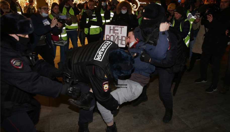 Police officers detain a man holding a placard reading "No war" during a protest at Pushkinskaya Square on February 24, 2022 in Moscow, Russia. (Photo by Konstantin Zavrazhin/Getty Images)