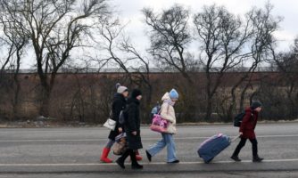 An Ukrainian family walks towards the Medyka-Shehyni border crossing between Ukraine and Poland as they flee the conflict in their country, near the Ukrainian village of Tvirzha, some 20km from the border, on February 28, 2022.