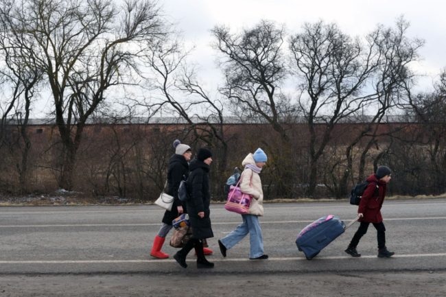 An Ukrainian family walks towards the Medyka-Shehyni border crossing between Ukraine and Poland as they flee the conflict in their country, near the Ukrainian village of Tvirzha, some 20km from the border, on February 28, 2022.