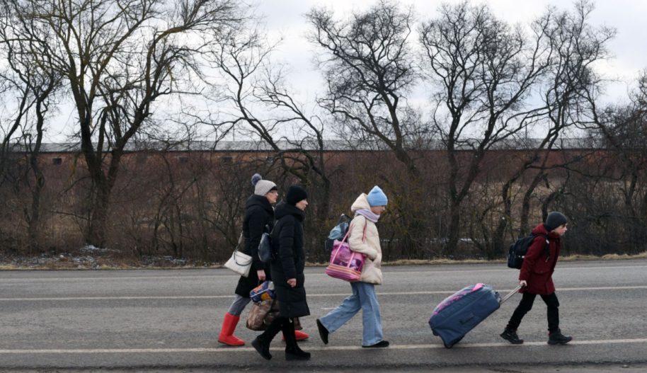An Ukrainian family walks towards the Medyka-Shehyni border crossing between Ukraine and Poland as they flee the conflict in their country, near the Ukrainian village of Tvirzha, some 20km from the border, on February 28, 2022.