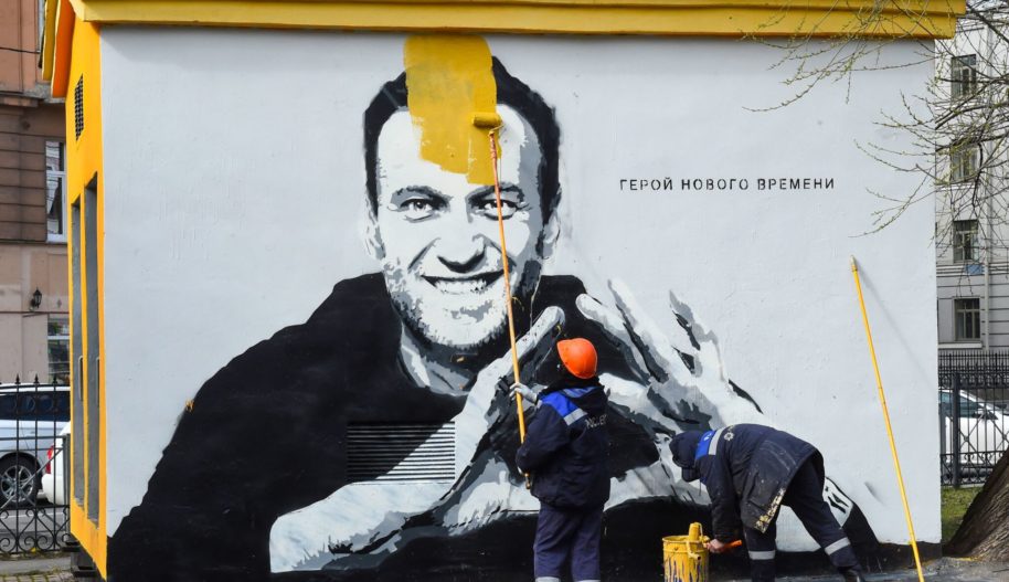 A worker paints over graffiti of jailed Kremlin critic Alexei Navalny in Saint Petersburg on April 28, 2021. (Photo by OLGA MALTSEVA/AFP via Getty Images