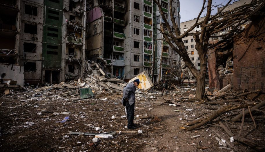 A man stands in front of a residential building damaged in yesterday's shelling in the city of Chernihiv on March 4, 2022. Photo by DIMITAR DILKOFF/AFP via Getty Images