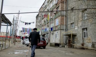 An older man walks across the courtyard of a dormitory for displaced persons in Baku, Azerbaijan.