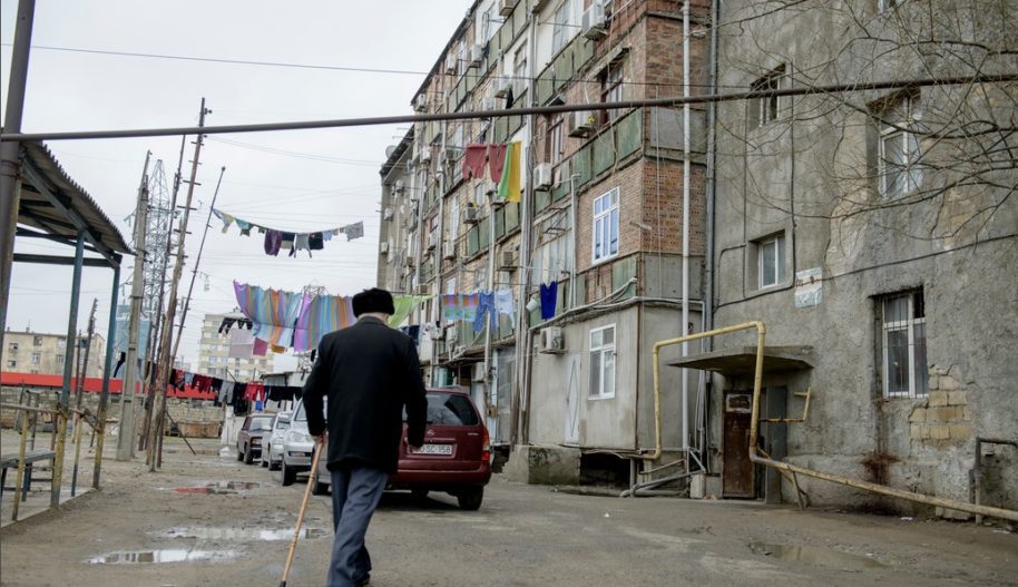 An older man walks across the courtyard of a dormitory for displaced persons in Baku, Azerbaijan.