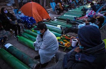 People camp as they wait to refill empty oxygen cylinders in Villa El Salvador, on the southern outskirts of Lima, on February 25, 2021, amid the COVID-19 coronavirus pandemic. Photo by ERNESTO BENAVIDES / AFP