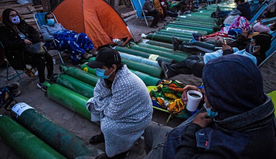 People camp as they wait to refill empty oxygen cylinders in Villa El Salvador, on the southern outskirts of Lima, on February 25, 2021, amid the COVID-19 coronavirus pandemic. Photo by ERNESTO BENAVIDES / AFP