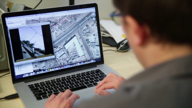 Pracownik Zespołu Kryzysowego Amnesty przed komputerem analizuje zdjęcia satelitarne.