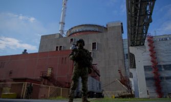 Rosyjski żołnierz stoi na straży przed drugim reaktorem Zaporoskiej Elektrowni Jądowej w Enerhodarze, 1 maja 2022.