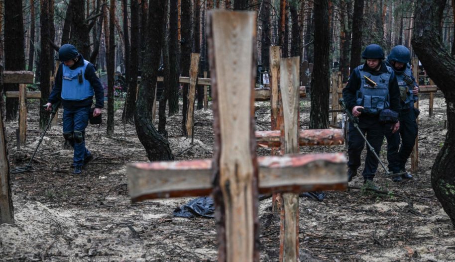 Ukraińscy żołnierze szukają min lądowych na miejscu pochówku w lesie na obrzeżach Izium, wschodnia Ukraina, 16 września 2022 r.
