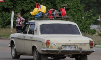 Samochód z ukraińskimi tablicami rejestracyjnymi zapakowany po brzegi bagażami, widziany w pobliżu punktu służącego filtracji ludności w regionie Ługańskim.