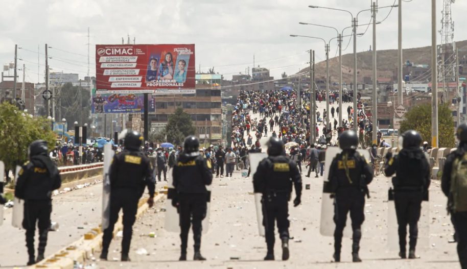 Protest zwolenników odsuniętego od władzy prezydenta Pedro Castillo stoją naprzeciwko rzędu policjantów w mieście Juliaca, 7 stycznia 2023.