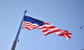 Flaga Stanów Zjednoczonych Ameryki Północnej powiewająca na sztandarze.