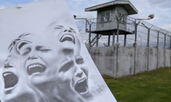 Zdjęcie grafiki zrobionej na papierze przez Karrara Espanola ogrodzenia kolczastego i wieżyczki strażniczej ośrodka detencyjnego w Litwie. Tytuł grafiki - :Scream the Mind (Krzyk umysłu). ©Karrar Español