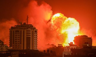 Kula ognia na niebie, w tle budynki mieszkalne, nalot bombowy na miasto Gaza.