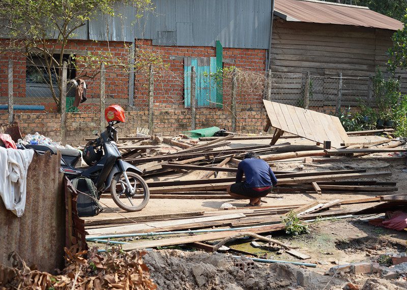 Zdjęcie z misji badawczej przeprowadzonej w marcu 2023 r. w Siem Reap w Kambodży, gdzie Amnesty uznała "dobrowolne" eksmisje w świątyniach Angkor Wat za przymusowe. Rząd twierdzi, że musi przemieścić ludzi, aby utrzymać status miejsca światowego dziedzictwa. Zdjęcie przedstawia mężczyznę, który rozbiera swój dom, aby przenieść się do miejsca relokacji.