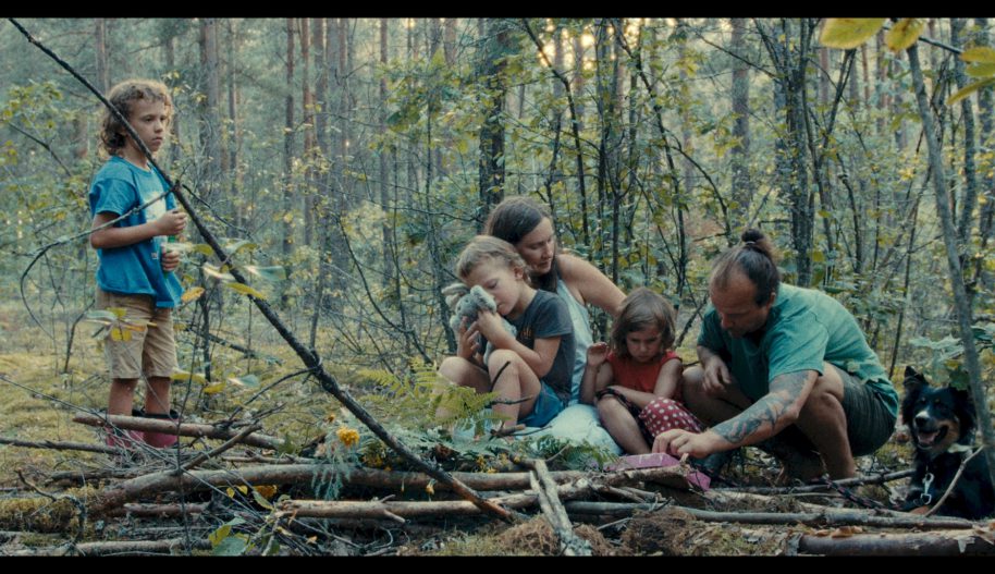 Kadr z filmu przedstawiający rodzinę w lesie.