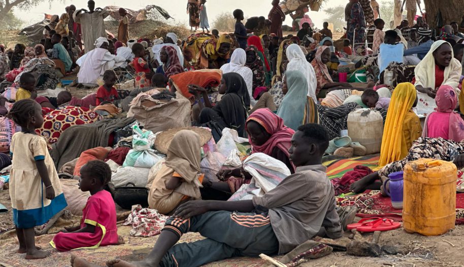 Duża grupa osób uchodźczych uciekających przed wojną, kobiety, mężczyźni i dzieci.