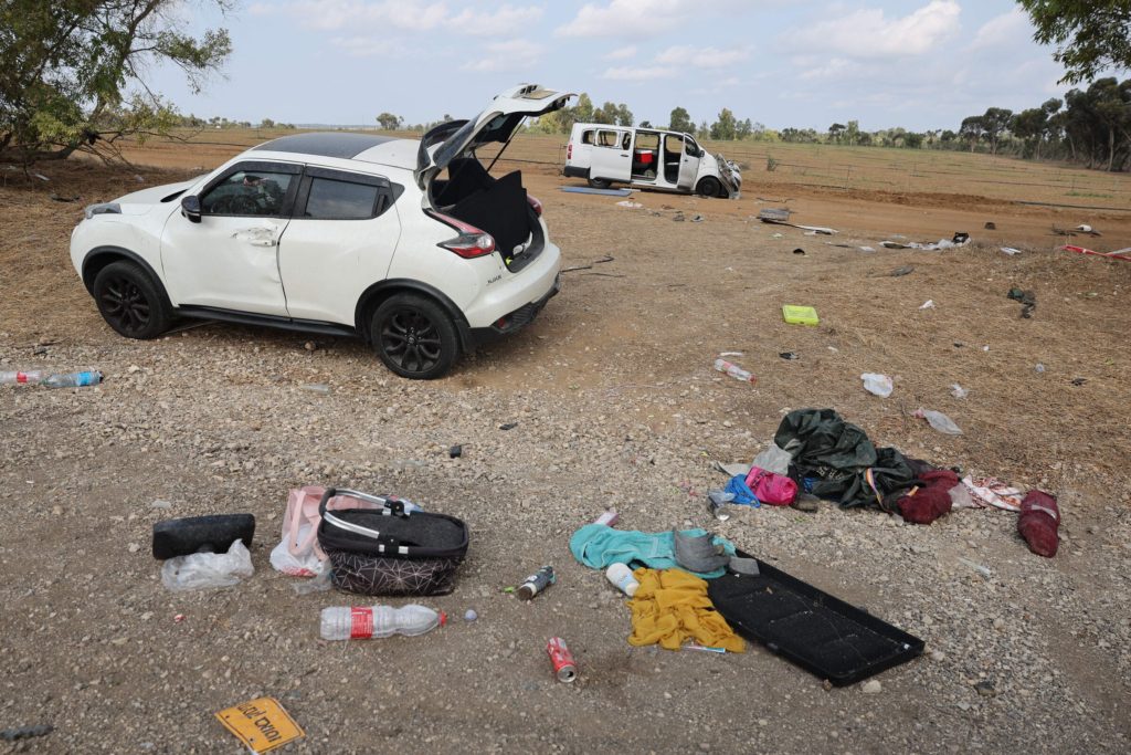 Porzucone dwa białe samochody, wokół rozrzucone rzeczy osobiste ofiar ataku.
