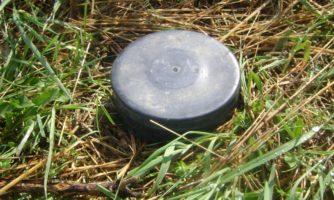 Mina przeciwpiechotna położona na trawie.