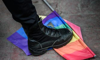 Policyjny but niszczący flagę LGBTI.