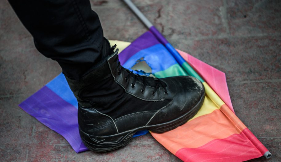 Policyjny but niszczący flagę LGBTI.